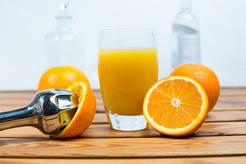 Glass of orange juice and a juice extractor