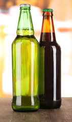 Bier in bottles on table on room background