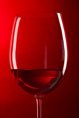 Glass of wine on bright red background