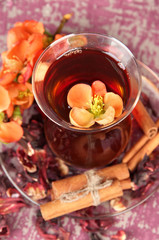 Herbal tea in glass cup, on color wooden background