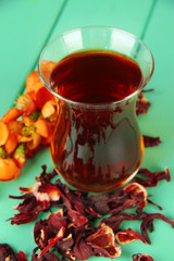 Herbal tea in glass cup, on color wooden background