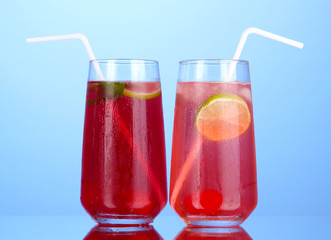 Two cherry cocktails with ice on dark blue background