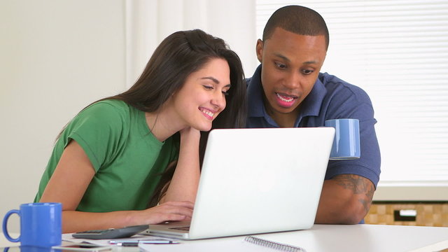 African american and caucasian couple paying bills together