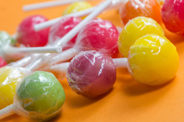 Fototapeta na wymiar colorful candy lollipops on orange background