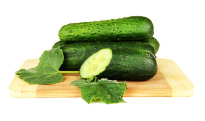 Tasty green cucumbers on color napkin, wooden background