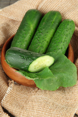 Tasty green cucumbers on sackcloth background