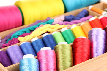 Colorful threads for needlework in wooden box close up
