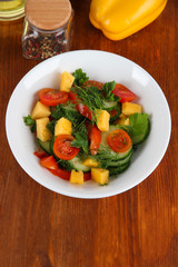 Light salad in plate on wooden table