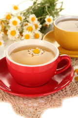 Obraz na płótnie Canvas Cups of herbal tea with camomiles close up