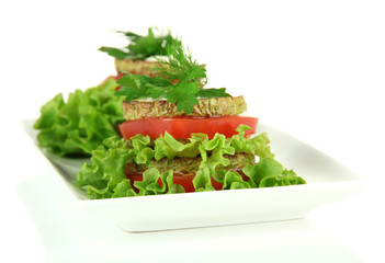 Tasty roasted marrow and tomato slices with salad leaves,