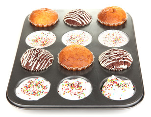 Tasty muffin cakes in baking tray isolated on white