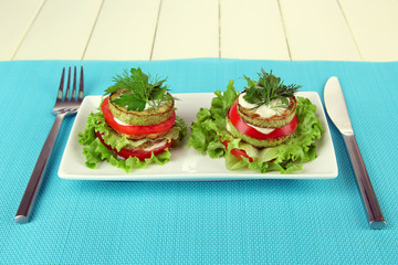 Tasty roasted marrow and tomato slices with salad leaves,
