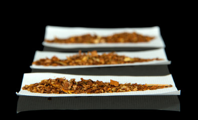 Tobacco and rolling papers, isolated on black