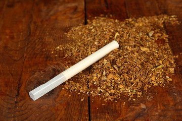 Tobacco and cigarette tubes on wooden background