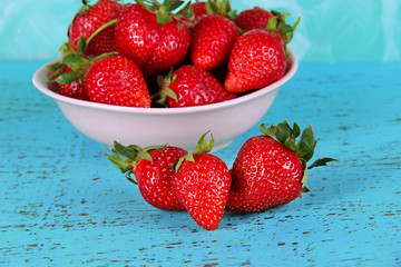 Strawberries in plate on blue background