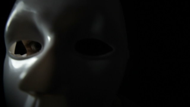 Spooky masked man over black background