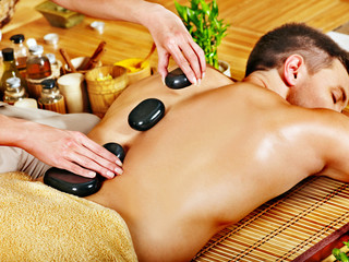Man getting stone therapy massage .