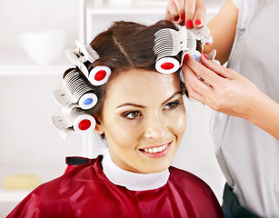 Woman wear hair curlers on head.