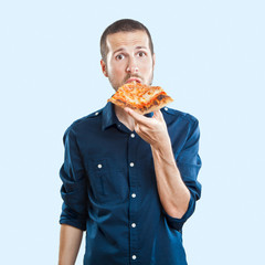 portrait of a young beautiful man eating a slice of pizza marghe