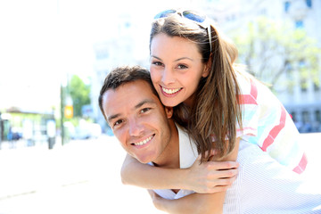 Fototapeta premium Man giving piggyback ride to girlfriend