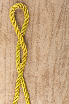Golden rope on wooden background