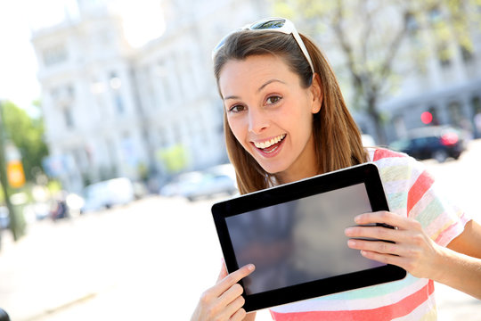 Cheerful Girl In Town Showing Tablet Screen