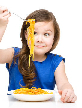 Little girl is eating spaghetti