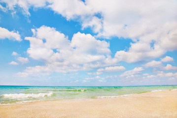 Fototapeta na wymiar Beautiful panorama of sea beach with waves and blue cloudy sky