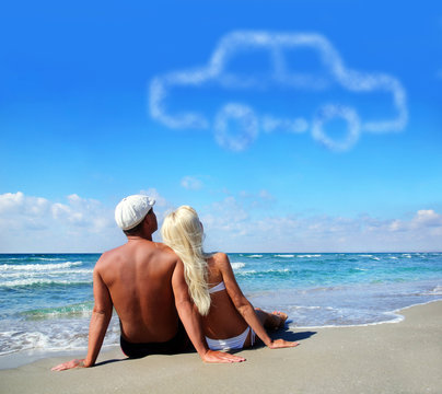 young couple on sea sand beach dreaming about the own car