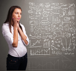 Fototapeta premium Pretty woman looking at stock market graphs and symbols