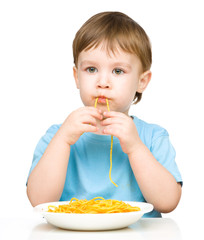 Little boy is eating spaghetti