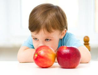 Fototapeta na wymiar Portrait of a sad little boy with apples