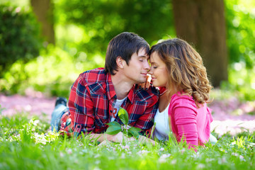 beautiful couple in love lying on green grass