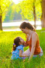 mother daughter girl and woman sitting on the green grass nature