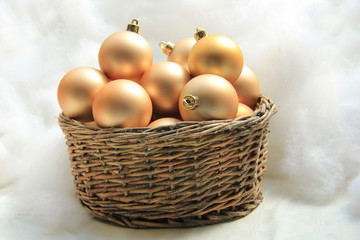Golden Christmas ornaments in a wicker basket