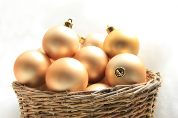 Golden Christmas ornaments in a wicker basket