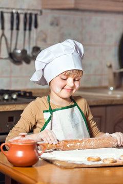 lovely girl in a chef's hat cooking sweet cake