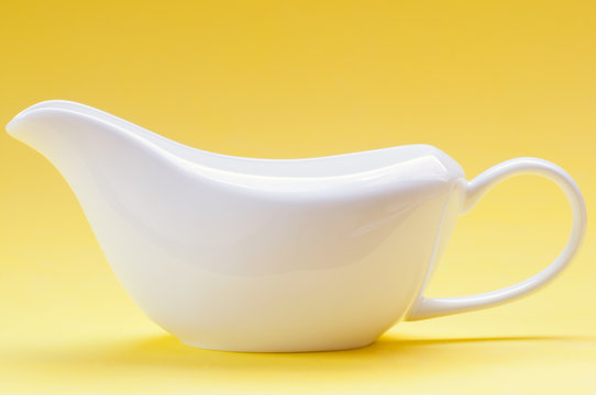 White ceramic gravy boat on a yellow background