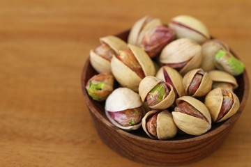 Pistachios in wooden bowl, close up