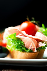 Sandwiches with prosciutto on plate