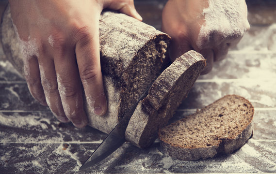Male hands slicing home-made bread