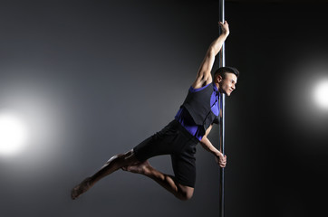 Pole dance man over black background with flashes
