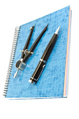 Blue spiral notebook with pen and drawing compass