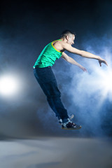 Fototapeta na wymiar Dancer posing on background with flashes and smoke