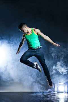 Dancer posing on background with flashes and smoke