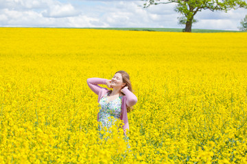 Fototapeta premium lachende frau im raps feld