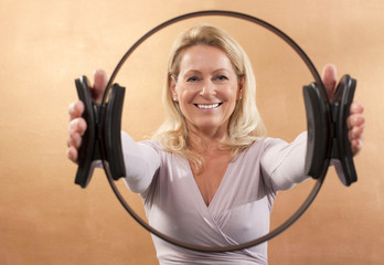 Frau hält Pilatesring