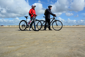 Paar mit dem Fahrrad am Sandstrand