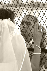 The groom kisses the bride through the bars