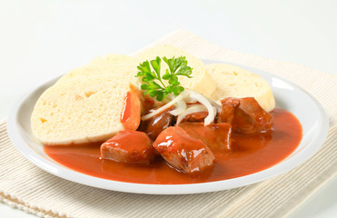 Pork meat in tomato sauce with dumplings